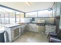 Modern outdoor kitchen featuring a grill, sink, and granite countertops at 10001 Newington Dr, Orlando, FL 32836