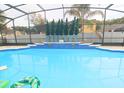 Inviting swimming pool with a screened enclosure and lush landscaping at 10001 Newington Dr, Orlando, FL 32836