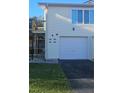 Exterior view of a light yellow building with an attached garage and balcony at 1022 Spring Meadow Dr # 1022, Kissimmee, FL 34741