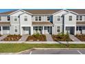 Three-unit townhome building with gray siding and landscaping at 10425 Folly Beach Rd, Orlando, FL 32827