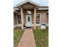 Inviting front entrance featuring a brick walkway and well-maintained landscaping at 149 Birmingham Dr, Kissimmee, FL 34758