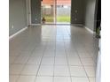 Spacious living room featuring ceramic tile floors and sliding glass doors that lead to the backyard at 149 Birmingham Dr, Kissimmee, FL 34758