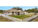 Charming house with a white picket fence and solar panels on the roof at 203 North Cir, Davenport, FL 33837