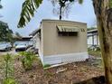 Tan mobile home with a white lattice fence at 215 4Th St, Orlando, FL 32824