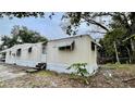 Tan mobile home with mature trees and a small yard at 215 4Th St, Orlando, FL 32824