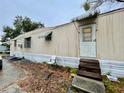 Tan mobile home with awnings and wooden steps at 215 4Th St, Orlando, FL 32824