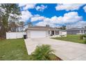House exterior showcasing a driveway and fenced yard at 3 Pecan Drive Loop, Ocala, FL 34472