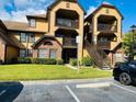 Condo building with private balconies, brown trim, and ample parking at 345 Forestway Cir # 106, Altamonte Springs, FL 32701