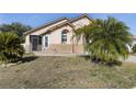Tan house with palm trees and a small patio at 4525 Oakbrook Ct, Kissimmee, FL 34746