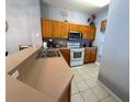 Well-equipped kitchen featuring laminate countertops, wooden cabinets, and a stainless steel microwave at 4557 Ada Ln, Kissimmee, FL 34746