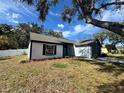 Single-story house with freshly painted white and dark gray exterior, showcasing a teal front door at 7450 Crooked Lake Cir, Orlando, FL 32818