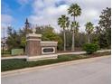 Community entrance with brick sign, mature trees, and lush landscaping at 7588 Assembly Ln, Reunion, FL 34747