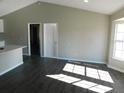 Bright living room with vaulted ceiling, dark laminate floors, and large windows at 1972 S Old Mill Dr, Deltona, FL 32725