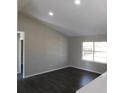 Living room with vaulted ceiling, dark laminate floors, and a view to the kitchen at 1972 S Old Mill Dr, Deltona, FL 32725