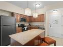 Modern kitchen with granite countertops, stainless steel appliances, and an island at 12538 Floridays Resort Dr # 411, Orlando, FL 32821