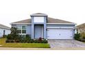 One-story home with gray exterior, white garage door, and landscaped yard at 1280 Tupelo Trl, Haines City, FL 33844