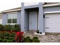 Light blue front door with landscaping and brick walkway at 1280 Tupelo Trl, Haines City, FL 33844