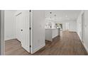 Bright hallway with light wood floors and white walls leading to kitchen at 13380 Sw 60Th Court Rd, Ocala, FL 34473