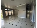 Open living room showcasing tile floors, large windows, neutral paint, and access to other rooms at 143 Glasgow Ct, Davenport, FL 33897