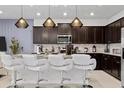 Modern kitchen with dark cabinets, granite counters, and island seating at 2190 Lelani Cir, Davenport, FL 33897