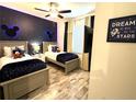 Charming bedroom featuring two twin beds, Mickey Mouse decor, and wood-look floors at 2929 Caribbean Soul Dr, Kissimmee, FL 34747