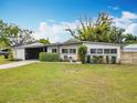 Inviting single-story home featuring a manicured lawn and an eye-catching orange front door at 420 Sunrise Dr, Orlando, FL 32803