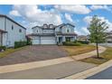 Two-story house with three-car garage and landscaped front yard at 8024 Leaf Grove Cir, Orlando, FL 32836