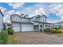 Two-story house with three-car garage and landscaped front yard at 8024 Leaf Grove Cir, Orlando, FL 32836