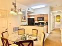 Cozy dining area featuring a glass table, woven chairs, and a view of the kitchen at 8100 Poinciana Blvd # 2405, Orlando, FL 32821