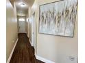 Bright hallway with dark wood floors and large art piece at 1015 Sabine Pl, Kissimmee, FL 34759
