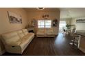 Living room with light beige couches and dark wood floors at 1015 Sabine Pl, Kissimmee, FL 34759