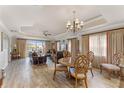 Spacious living room with wood-style tile flooring, elegant curtains, and comfortable furniture at 1108 Sunset View Cir # 204, Reunion, FL 34747