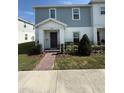 Charming two-story townhome featuring a well-maintained lawn and brick walkway leading to the front entrance at 1158 Sand Torch, Davenport, FL 33837