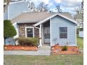 Inviting exterior featuring blue siding, brick accents, and colorful flower beds enhancing curb appeal at 118 Hidden Arbor Ct, Sanford, FL 32773