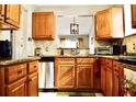 Well-lit kitchen featuring stainless steel appliances, tile backsplash and beautiful wood cabinetry at 118 Hidden Arbor Ct, Sanford, FL 32773