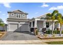 Two-story house with gray siding, two-car garage, and palm trees at 1783 Can Do Way, Kissimmee, FL 34744