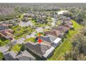 An aerial view of a single-story home in a neighborhood with winding streets at 203 Los Gatos Pl, Poinciana, FL 34759