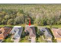 An aerial view of a single-story home with a sprawling forest in the background at 203 Los Gatos Pl, Poinciana, FL 34759