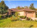 Charming single-story home with a well-manicured lawn and lush tropical landscaping at 203 Los Gatos Pl, Poinciana, FL 34759