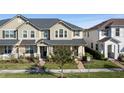 Tan townhome with gray roof, front porch, and landscaping at 2455 Varenna Loop # 1, Kissimmee, FL 34741