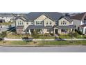 Tan townhome with gray roof, front porch, and landscaping at 2455 Varenna Loop # 1, Kissimmee, FL 34741