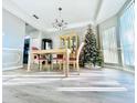 Elegant dining area with decorative light fixture, hardwood floors, and a view of the Christmas tree at 2949 Zaharias Dr, Orlando, FL 32837