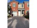 Two-story townhome with a two-car garage and brick paver driveway at 3459 Allegra Cir, St Cloud, FL 34772