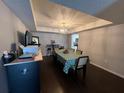 Bright dining area featuring modern light fixture, wooden floors, and view into kitchen space at 4575 S Texas Ave # 207, Orlando, FL 32839