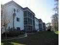 Exterior view of building showing multiple stories with balconies overlooking a green lawn and mature trees at 4575 S Texas Ave # 207, Orlando, FL 32839