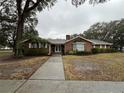 Brick house with a wide driveway and lush green lawn at 5030 Haywood Ruffin Rd, St Cloud, FL 34771