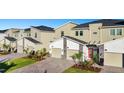 Row of tan townhomes with two-car garages and landscaping at 8879 Cabot Cliffs Dr # 103, Davenport, FL 33896