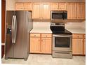 Stainless steel appliances and light wood cabinets in this updated kitchen at 12414 Baleria Cv # 108, Orlando, FL 32837