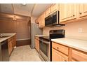 Modern kitchen with stainless steel appliances and light wood cabinets at 12414 Baleria Cv # 108, Orlando, FL 32837