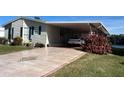 Single-wide manufactured home with carport, and partial lake view at 1296 Skyline Dr, Tavares, FL 32778